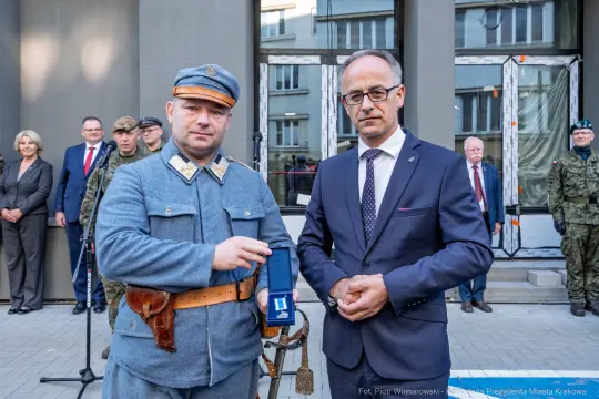 Wręczenie odznaczenia w uroczystości z udziałem wojskowych i przedstawicieli władz.