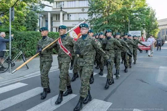 Żołnierze w mundurach wojskowych maszerują podczas parady.