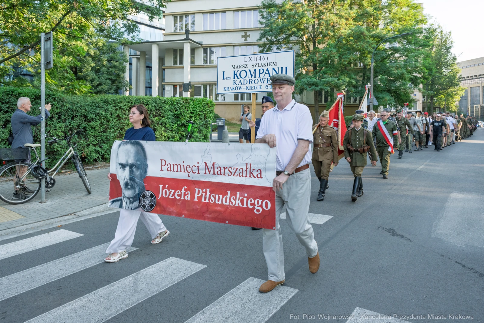 Marsz z transparentem upamiętniającym Józefa Piłsudskiego, uczestnicy w mundurach historycznych.  Autor: Piotr Wojnarowski