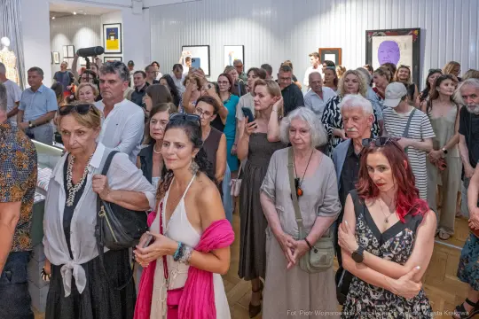 Tłum ludzi na wydarzeniu artystycznym, różnorodne reakcje i emocje uczestników.