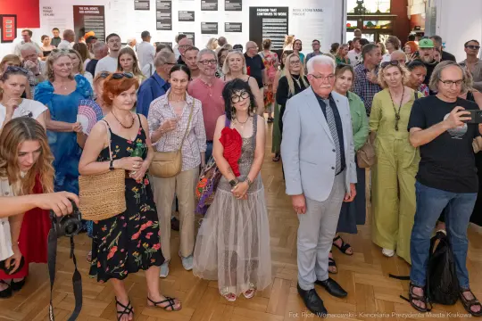 Tłum ludzi na wydarzeniu kulturalnym, różnorodne stroje i emocje uczestników.