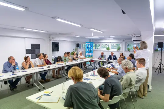 Spotkanie grupy ludzi przy stole w sali konferencyjnej.