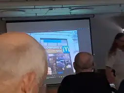 McDonald's z widocznym logo i klientami w kolejce.