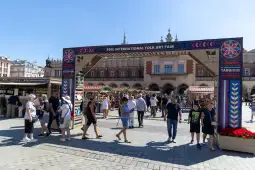 Międzynarodowe Targi Sztuki Ludowej z tłumem ludzi i straganami na rynku.