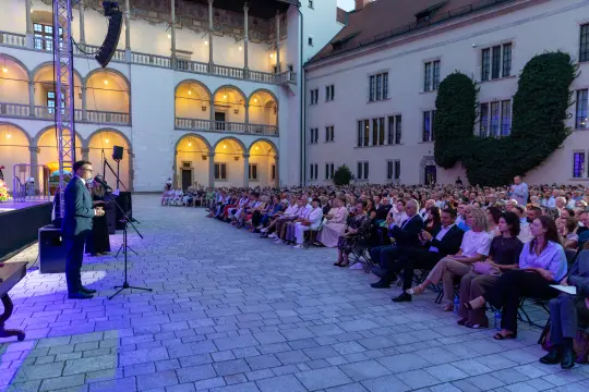 Wydarzenie na świeżym powietrzu z dużą publicznością w historycznym otoczeniu.