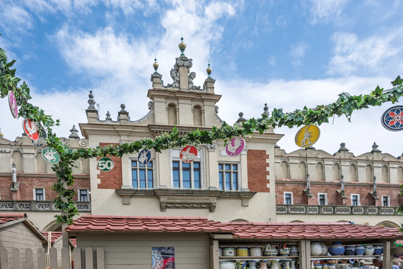 Budynek z ozdobnym dachem i dekoracjami, otoczony zielonymi pnączami i kolorowymi girlandami.  Autor: Piotr Wojnarowski