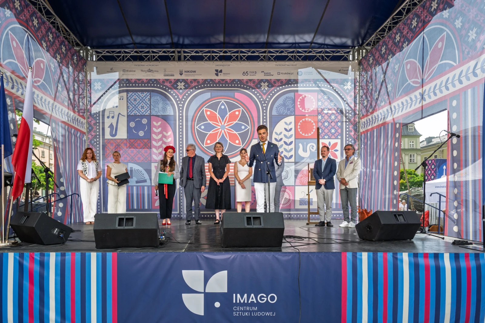 Otwarcie wydarzenia kulturalnego z mówcami na scenie i dekoracjami w tle.  Autor: Piotr Wojnarowski