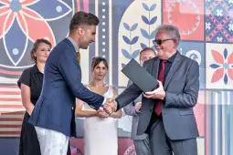 Uroczystość wręczenia nagrody z uśmiechniętymi uczestnikami.