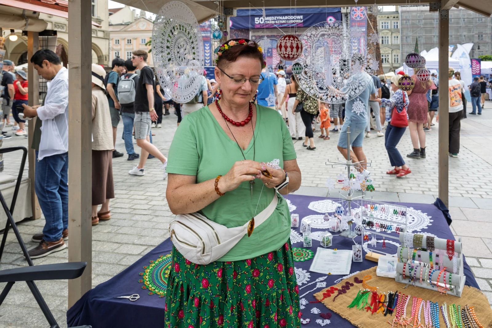 Kobieta w tradycyjnym stroju ludowym sprzedaje rękodzieło na festiwalu.  Autor: Piotr Wojnarowski