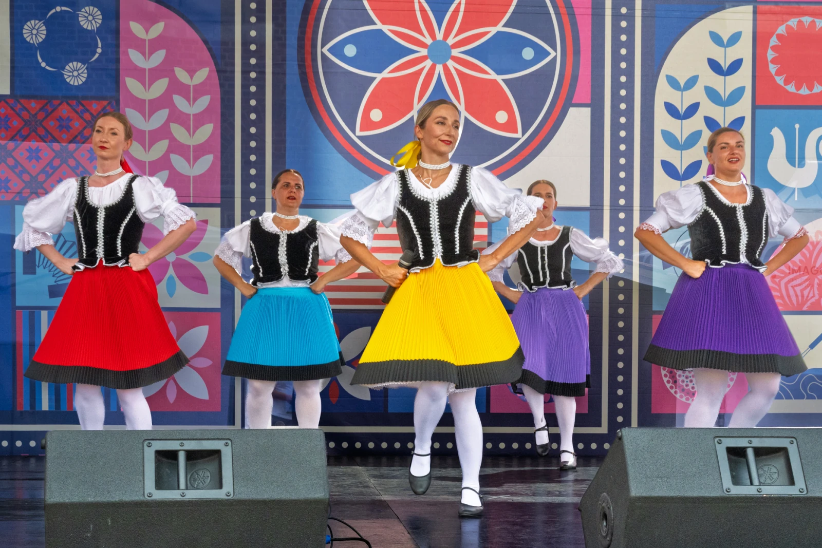 Grupa tancerek w kolorowych spódnicach wykonująca tradycyjny taniec ludowy.  Autor: Piotr Wojnarowski