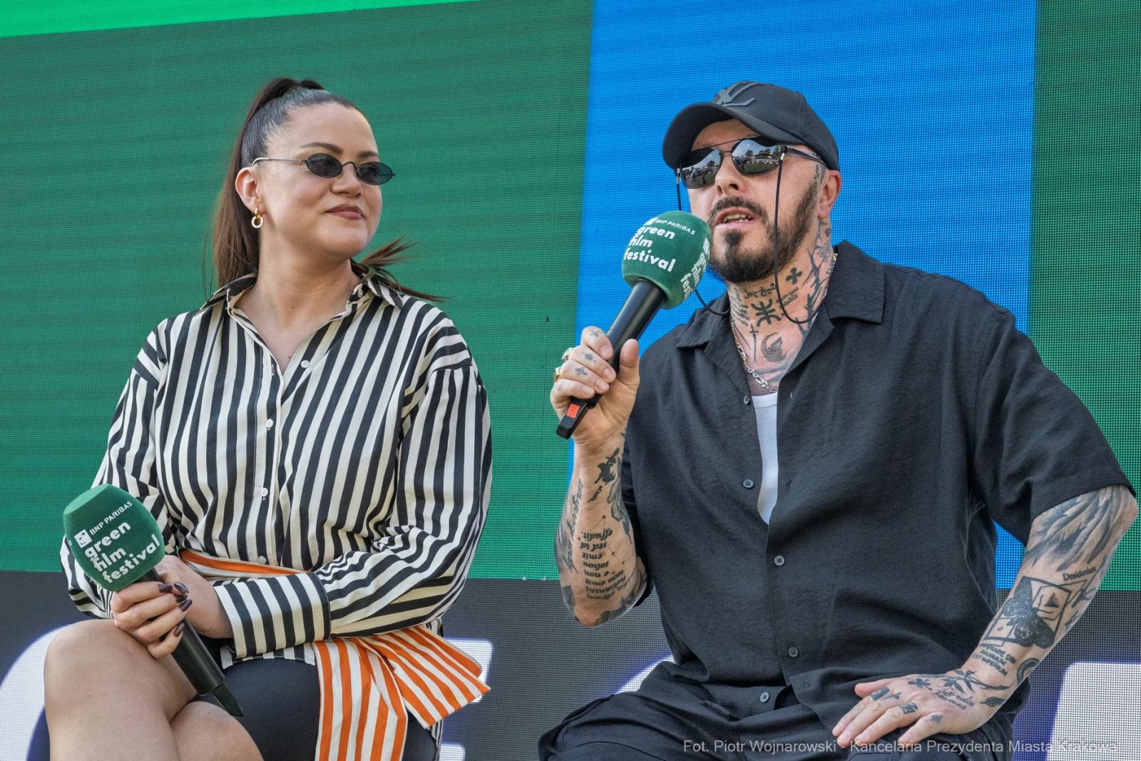 Dwoje ludzi siedzących na scenie, rozmawiających i trzymających mikrofony.  Autor: Piotr Wojnarowski