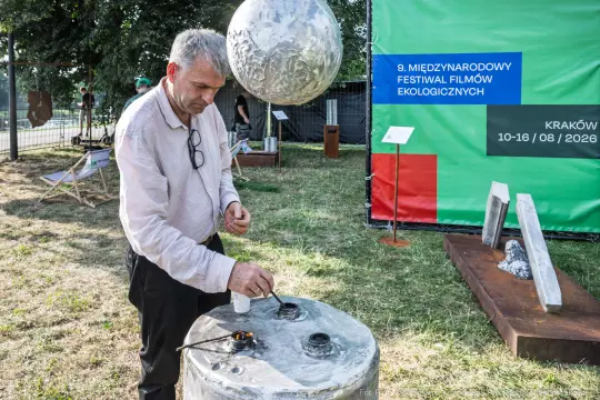 Mężczyzna pracujący przy instalacji artystycznej na festiwalu filmowym w Krakowie.