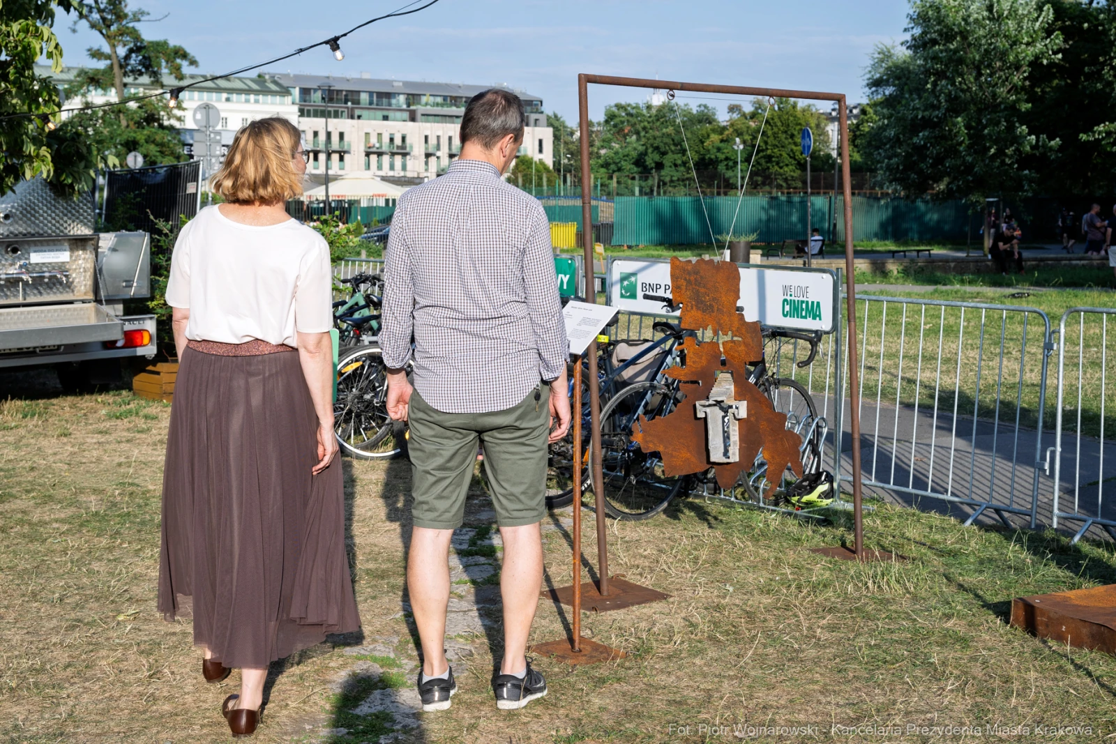 Para spacerująca obok instalacji artystycznej w plenerze, w tle rowery i zieleń.  Autor: Piotr Wojnarowski