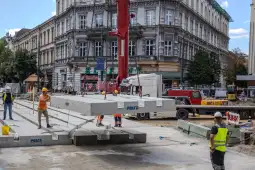 Pracownicy budowlani montują betonowe elementy na placu budowy w mieście.