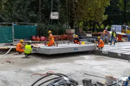 Pracownicy budowlani montują elementy konstrukcyjne na placu budowy.
