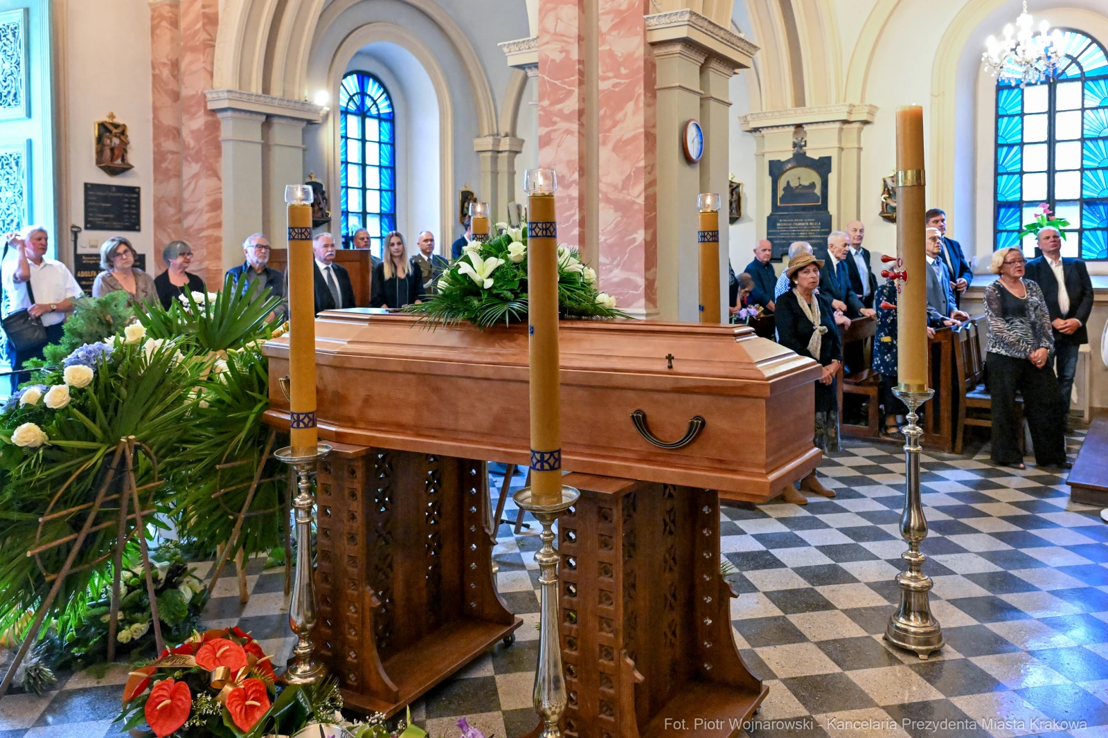 Trumna w kaplicy otoczona przez zgromadzonych ludzi i kwiaty.  Autor: Piotr Wojnarowski