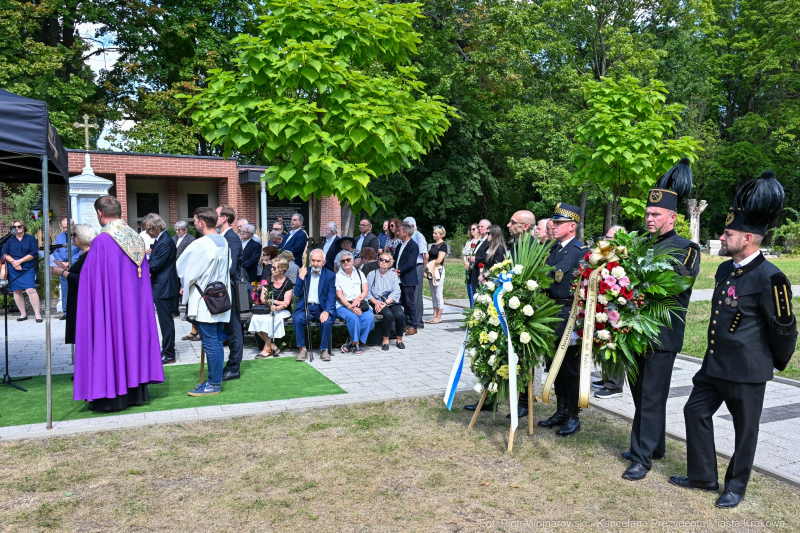 Ceremonia złożenia wieńców w otoczeniu uczestników i zieleni.  Autor: Piotr Wojnarowski
