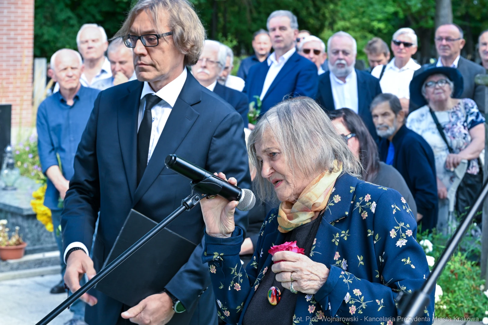Kobieta przemawia do zgromadzonego tłumu, trzymając różę. Mężczyzna obok trzyma dokumenty.  Autor: Piotr Wojnarowski