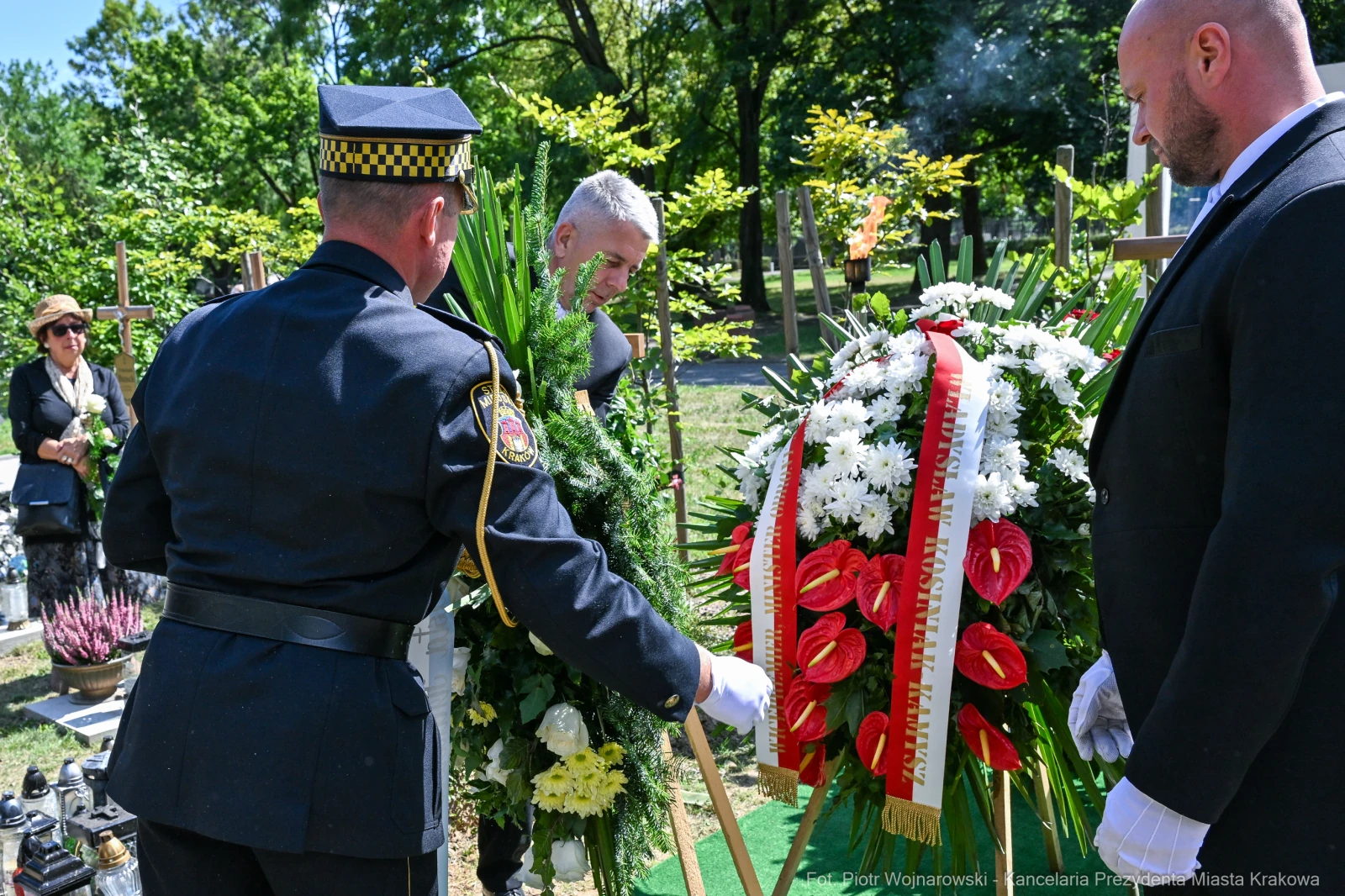 Ceremonia pogrzebowa z wieńcami i osobami w żałobie.  Autor: Piotr Wojnarowski