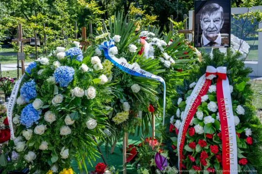 Kwiaty na grobie z portretem zmarłego.