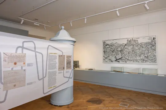 Ekspozycja w muzeum z dokumentami i rysunkiem przedstawiającym miasto.
