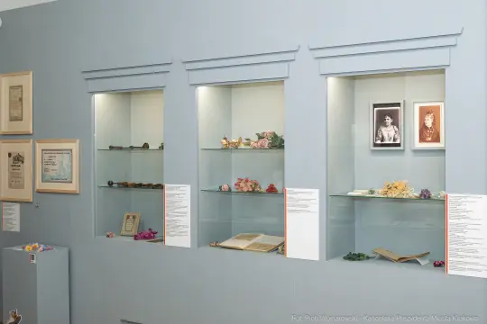 Wystawa z eksponatami w witrynach, w tym fotografie i przedmioty historyczne.