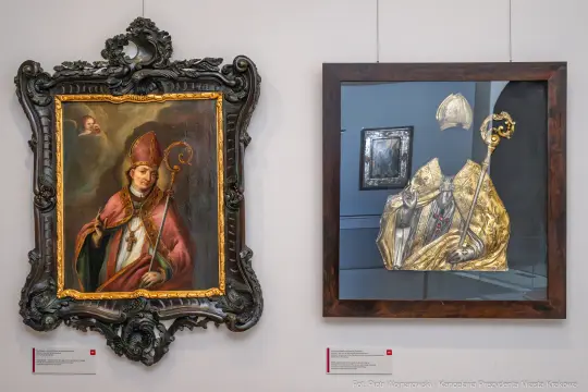 Portret biskupa w bogatej ramie obok złotych insygniów w eleganckiej oprawie.