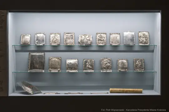 Zbiór srebrnych tabliczek i ozdób w muzeum.