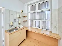 Kuchnia z białymi kafelkami, zlewem i dużym oknem.