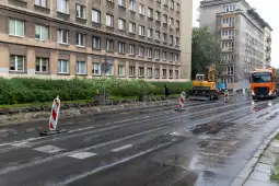 Remont ulicy z maszynami budowlanymi i oznakowaniem drogowym.