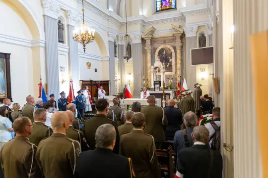 Msza w kościele z obecnością wojskowych i flag narodowych.