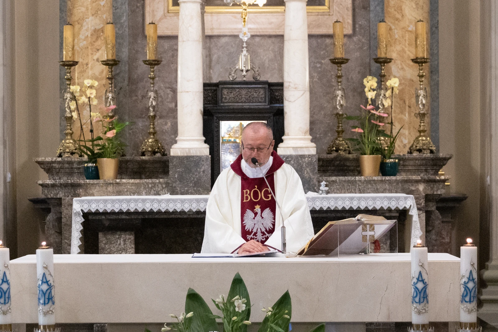 Ksiądz odprawiający mszę w kościele, z ołtarzem w tle.  Autor: Bogusław Świerzowski