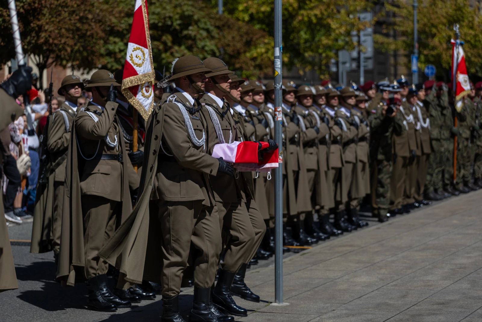 Żołnierze w mundurach podczas ceremonii, trzymający flagę i sztandary.  Autor: Bogusław Świerzowski