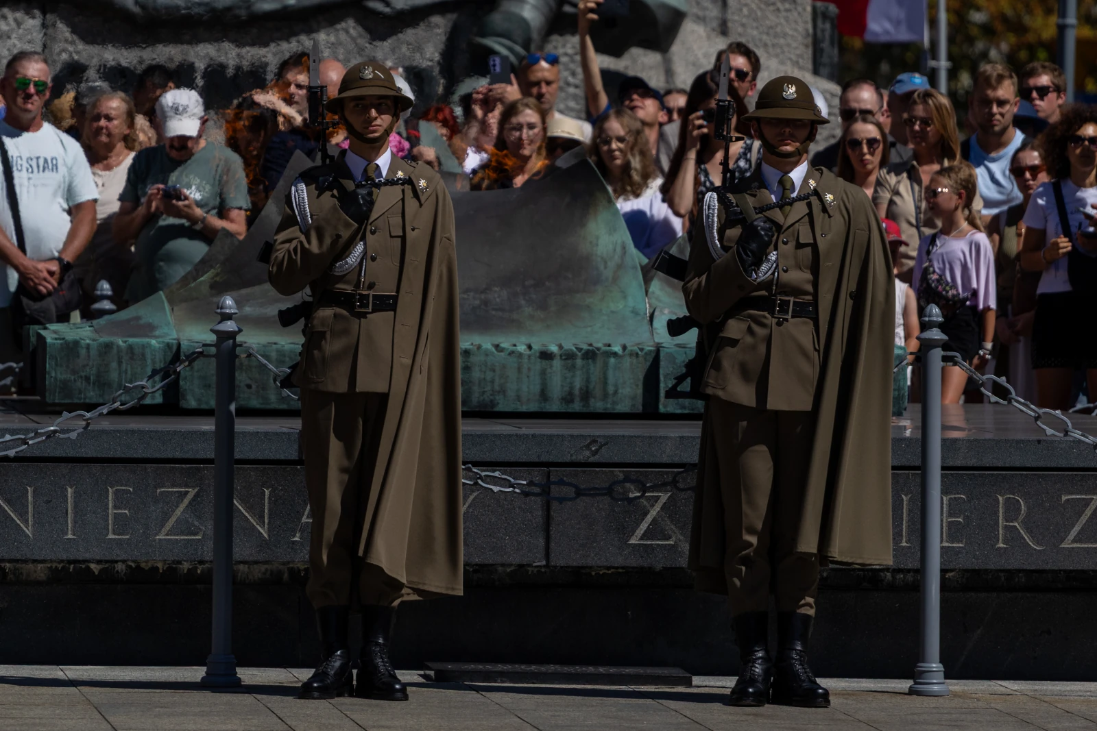 Dwaj żołnierze w mundurach ceremonialnych podczas uroczystości, tłum ludzi w tle.  Autor: Bogusław Świerzowski