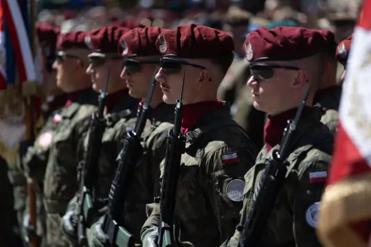Żołnierze w mundurach z beretami, stojący w szyku podczas ceremonii wojskowej.
