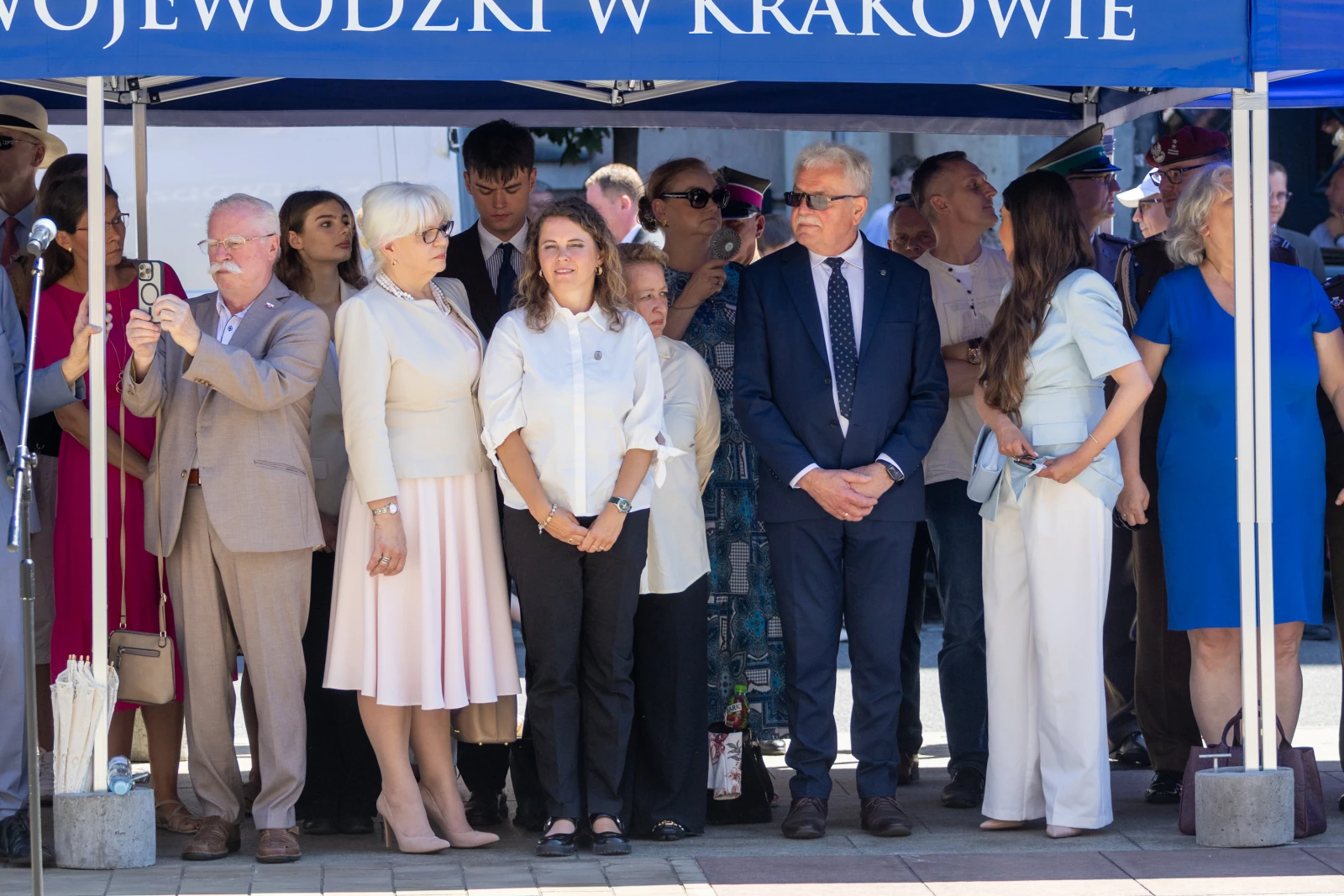 Grupa ludzi w formalnych strojach podczas wydarzenia pod namiotem.  Autor: Bogusław Świerzowski