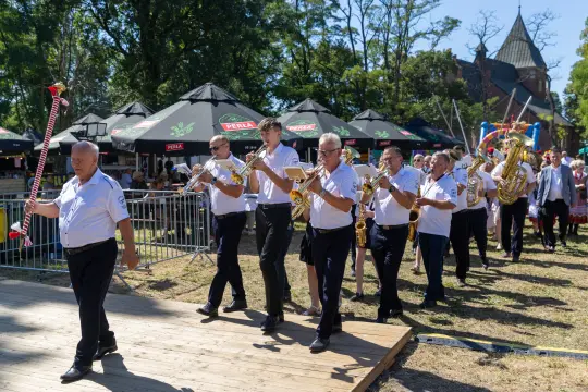 Orkiestra dęta w trakcie parady, grająca na świeżym powietrzu.