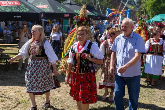 Grupa osób w tradycyjnych strojach ludowych podczas festiwalu.