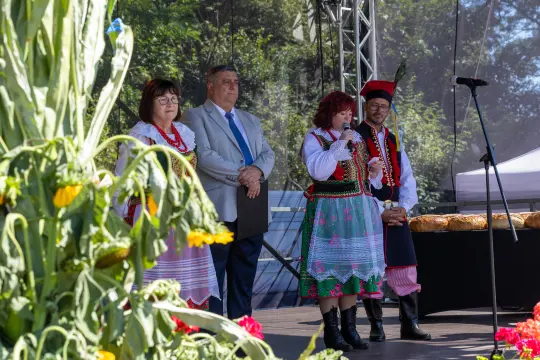 Osoby w tradycyjnych strojach ludowych podczas wystąpienia na scenie.