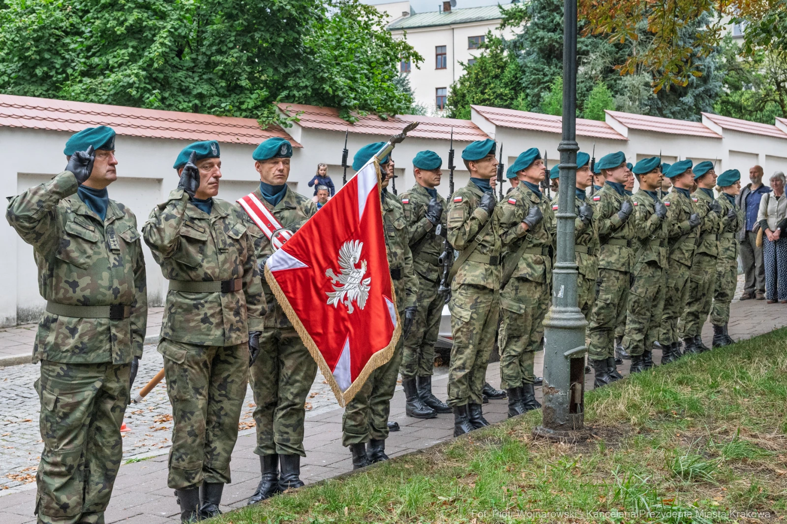 Żołnierze w mundurach wojskowych składają honory z flagą Polski.  Autor: Piotr Wojnarowski