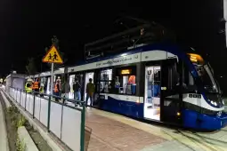 Tramwaj na przystanku w Krakowie, pasażerowie wsiadają i wysiadają.