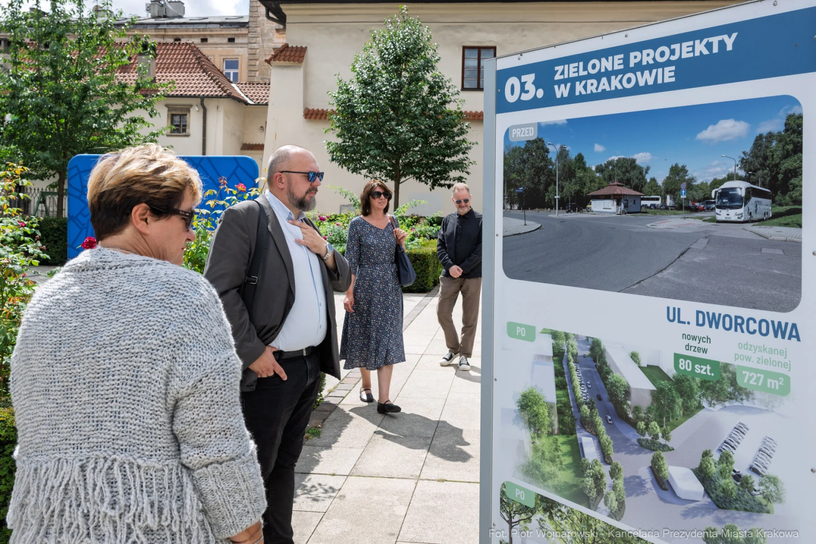 Grupa osób przy tablicy informacyjnej o zielonych projektach w Krakowie.  Autor: Piotr Wojnarowski