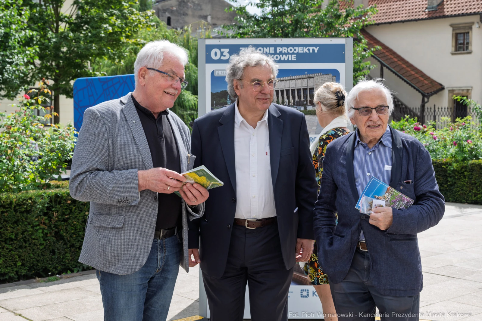 Trzech mężczyzn trzymających ulotki, stojących w miejskim otoczeniu.  Autor: Piotr Wojnarowski