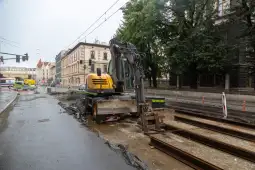 Maszyna budowlana pracująca przy remoncie torów tramwajowych na ulicy.