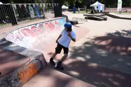 Chłopiec na rolkach wykonujący manewr w skateparku.