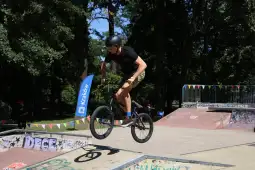 Mężczyzna wykonujący trik na rowerze BMX w skateparku.