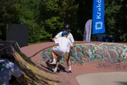 Dziecko uczące się jazdy na deskorolce w skateparku.