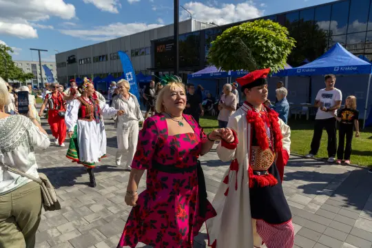 Kobiety i mężczyźni tańczą w tradycyjnych strojach ludowych podczas festiwalu.