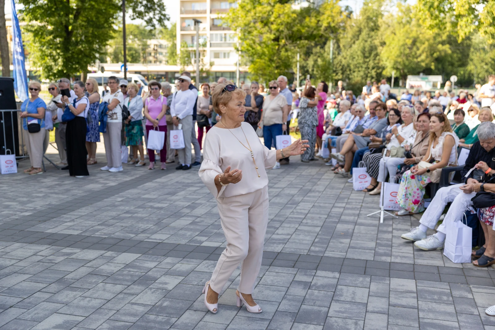 Kobieta tańcząca na tle zgromadzonej publiczności w parku.  Autor: Bogusław Świerzowski