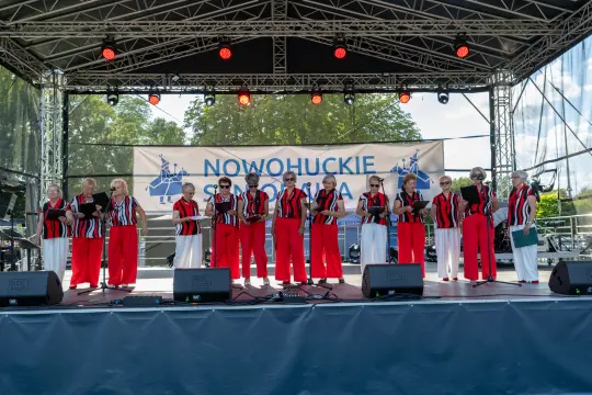 Chór w czerwono-czarnych strojach występuje na scenie podczas festiwalu.